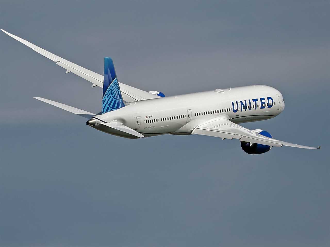 A United Airlines 787-10 Dreamliner against a dark blue sky.