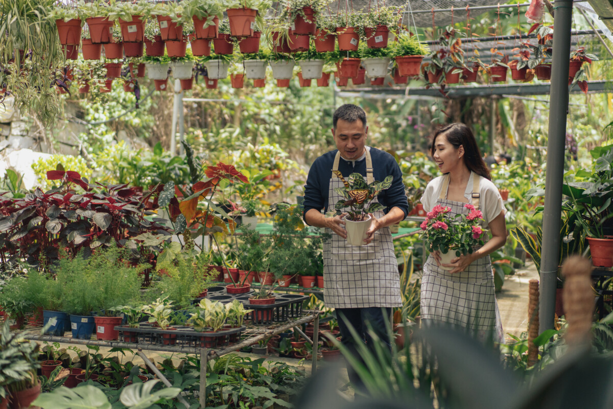 women and man holding flowers in a garden