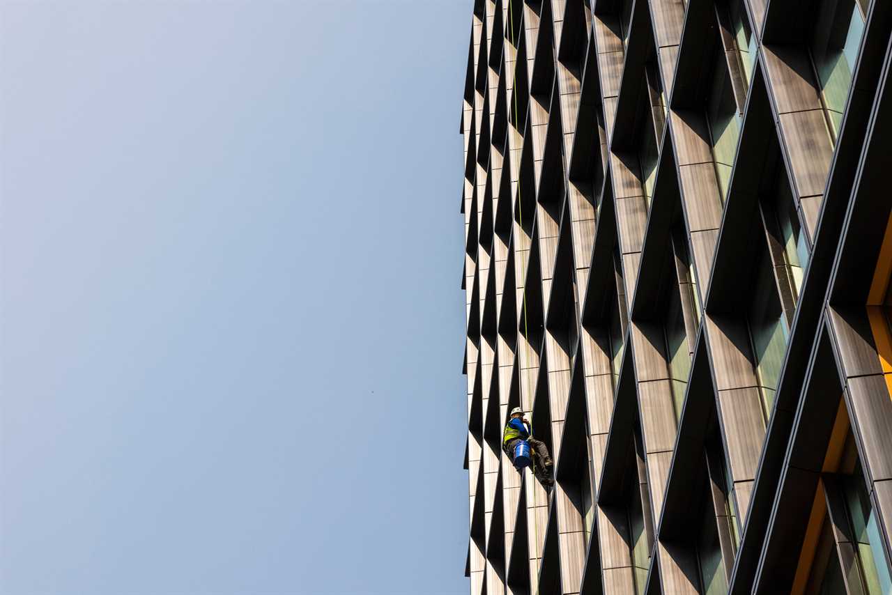 a construction worker on the side of a building at Metropolitan Park, the first phase of Amazon's HQ2 second headquarters in Arlington, Virginia