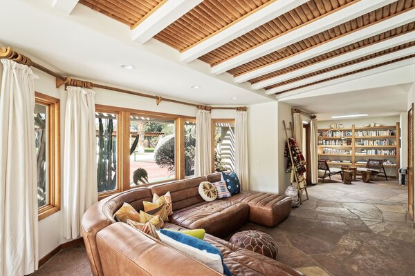 Inside, an open layout connects the main social spaces. "Flagstone floors flow throughout, adding another natural texture to the home's warm simplicity,