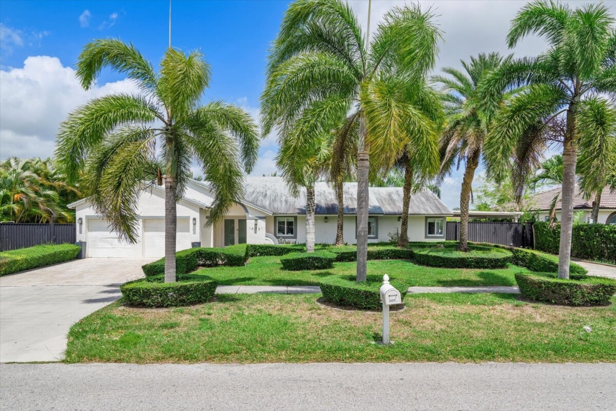 single story home with palm trees