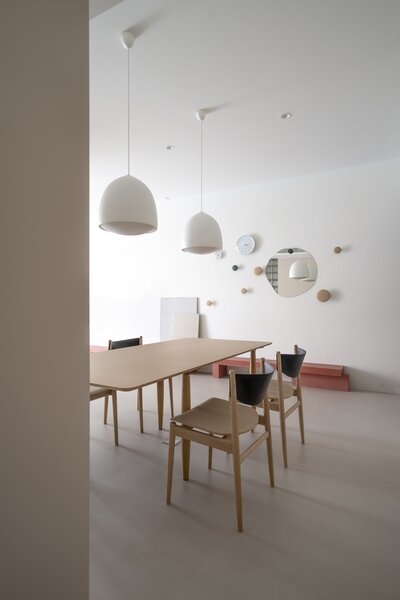 Bell-like Fritz Hansen dining room lamps and round wall elements enliven the living and dining room.  