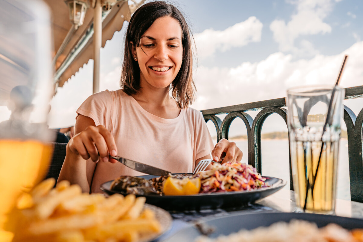 woman enjoying a meal by the sea.