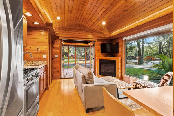 Inside an ESCAPE Home, panoramic windows flood the living room and kitchen with natural light, imbuing the room with added spaciousness.