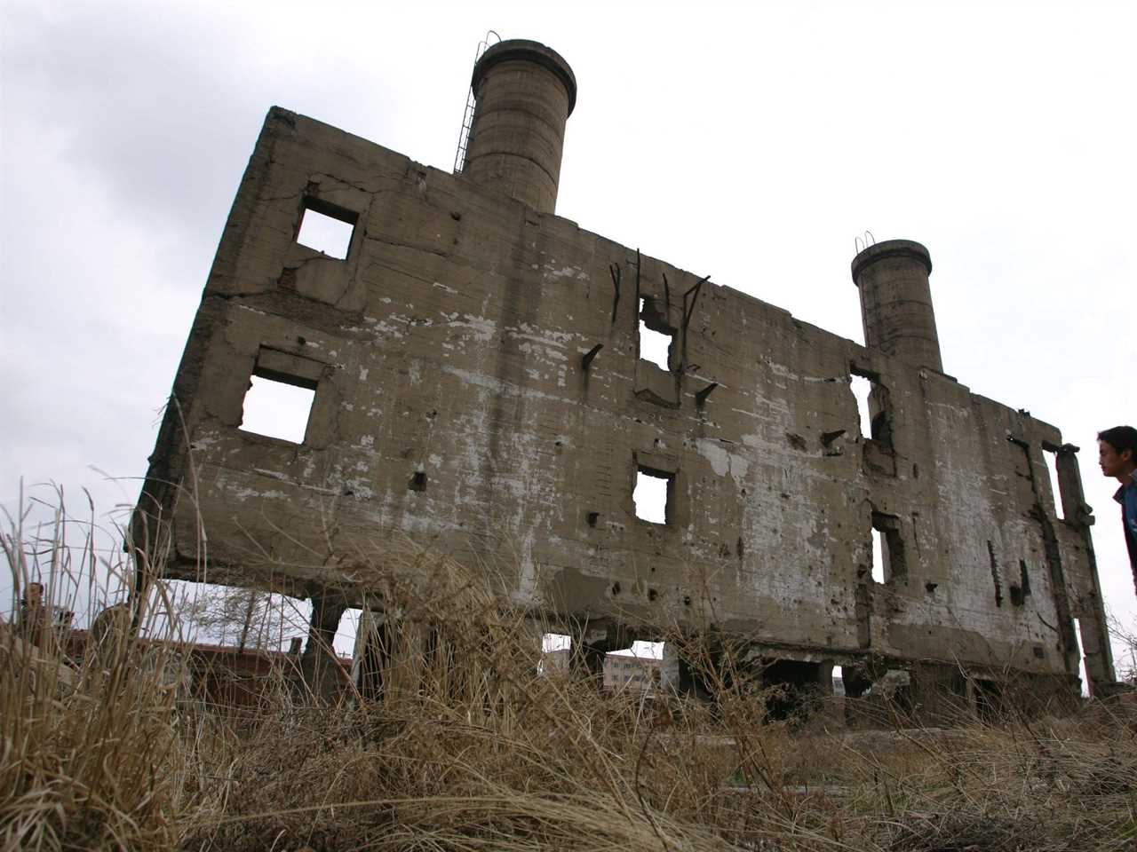 A Chinese man looks at the ruins of building of a Japanese germ warfare centre located in Harbin, capital of northeast China's Heilongjiang province, April 24, 2005.