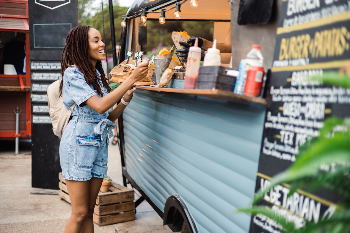 woman buying fast food at the food truck on the street