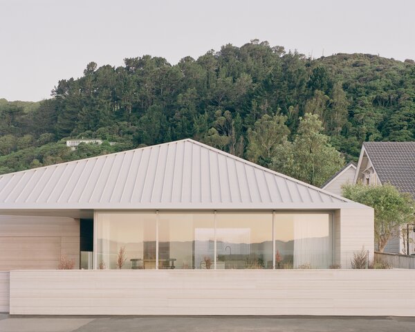 Warm Wood Finishes Sandwich the White Interiors of a Coastal Home in New Zealand