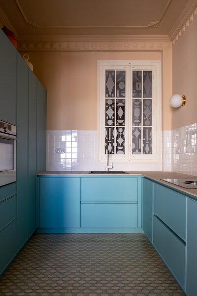 The kitchen was moved from a small space off the hallway and is now adjacent to the living area. The duck blue surfaces were made to match the floor tiling.