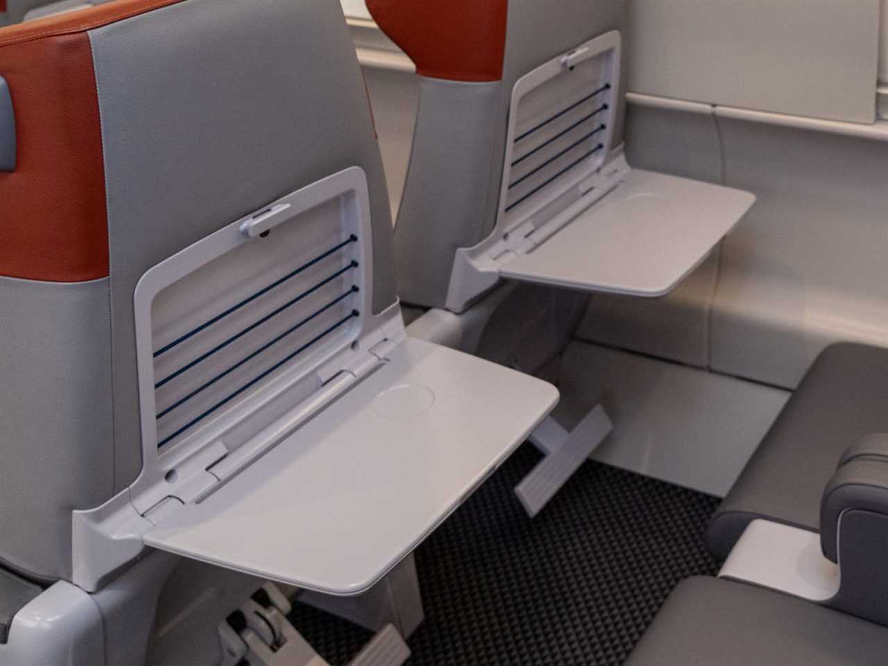 The new Amtrak Acela first class interior with tray tables flipped down.