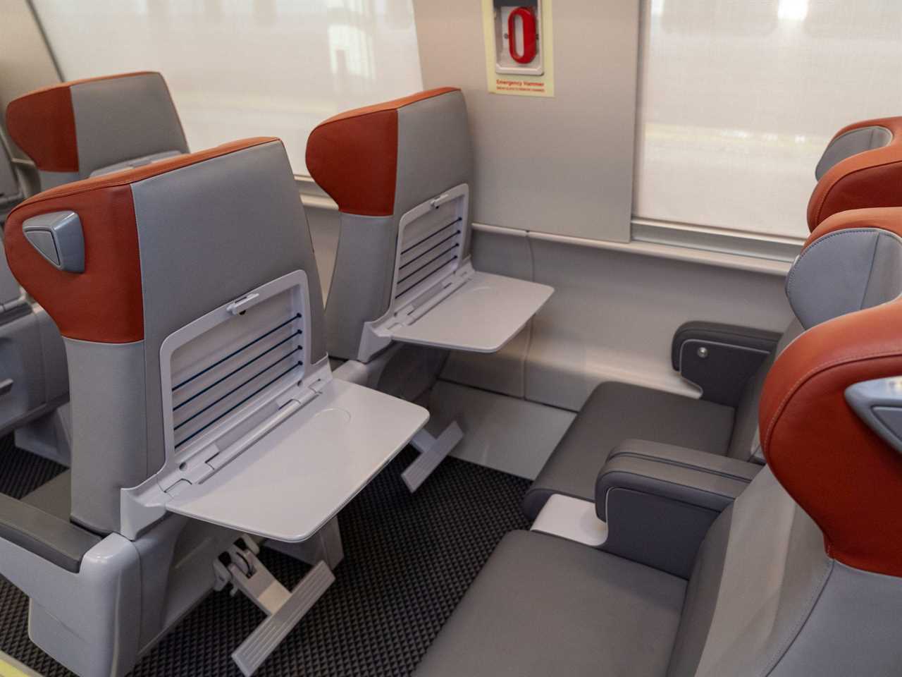 The new Amtrak Acela first class interior with tray tables flipped down.