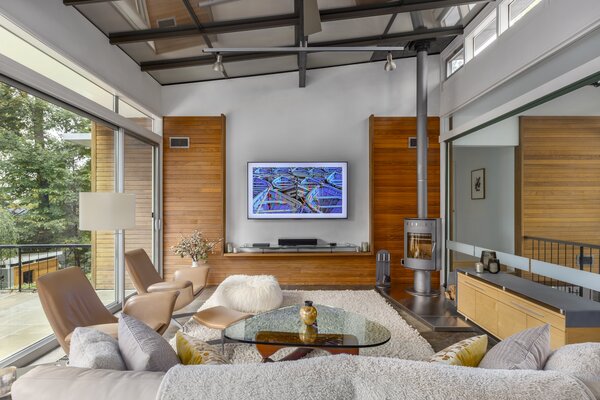 Expansive sliding glass doors and clerestory windows bathe the living spaces with natural light. Exposed beams and steel accents complement the handcrafted wooden details.