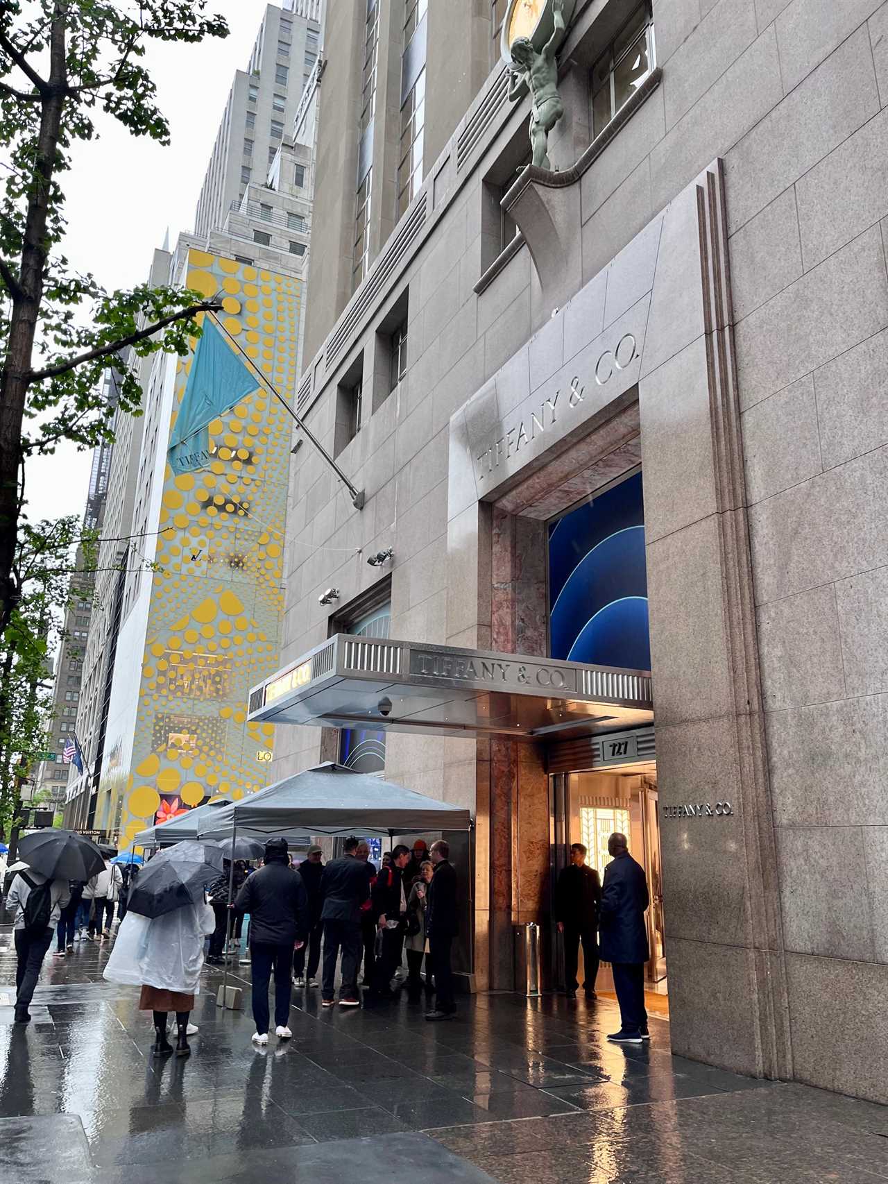 Exterior view of Tiffany store with people standing outside in rain