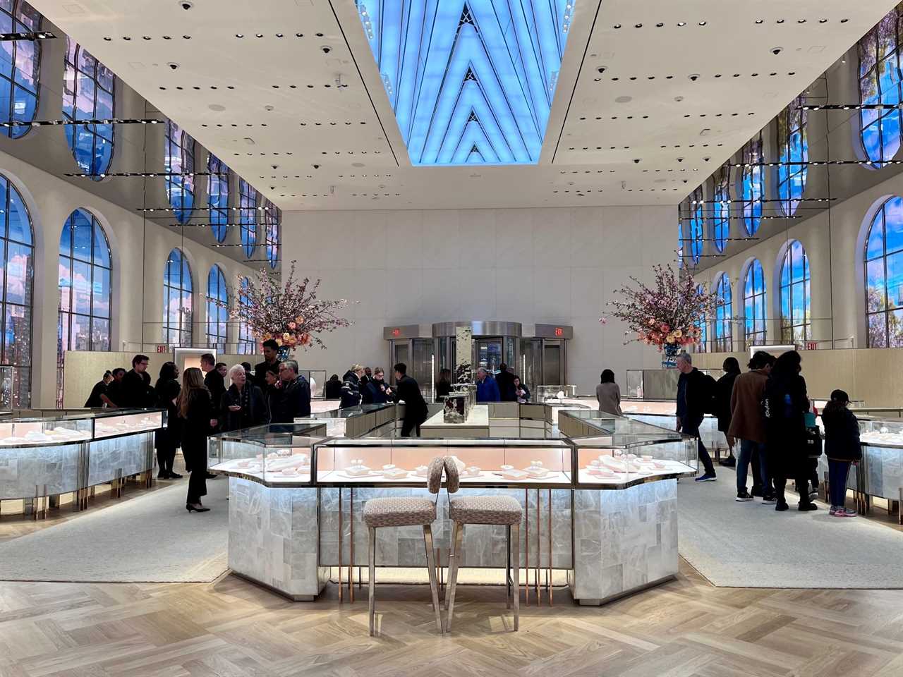 Interior of Tiffany store with customers standing at jewelry counters