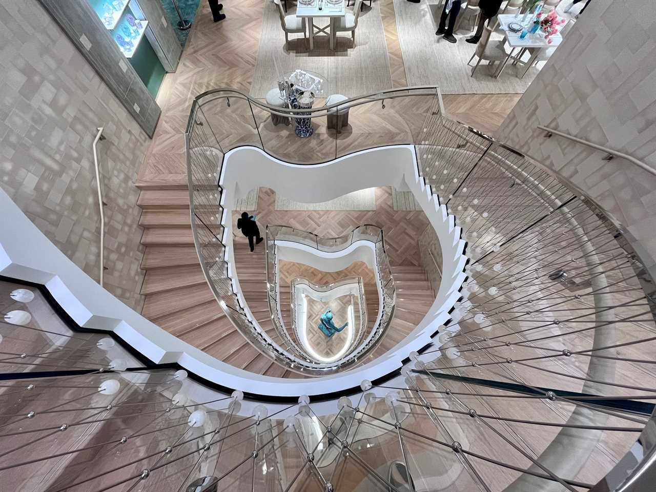 View down curved staircase from several stories up inside Tiffany store