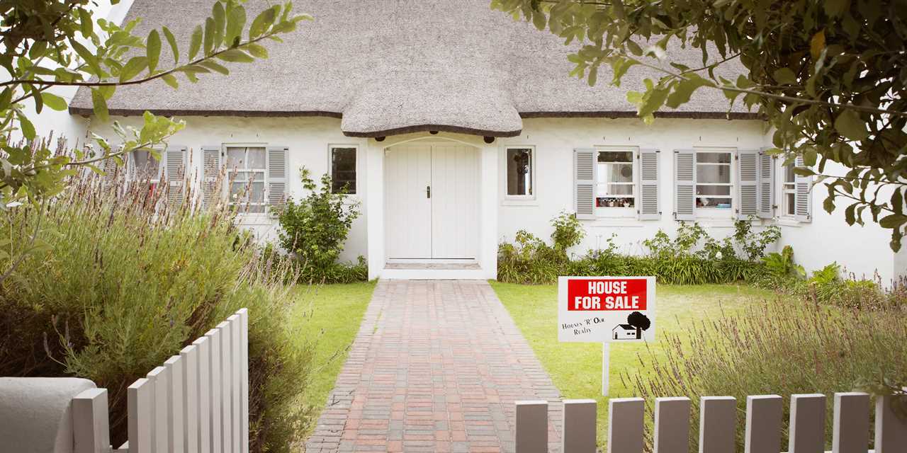 A house with a for sale sign in the front.