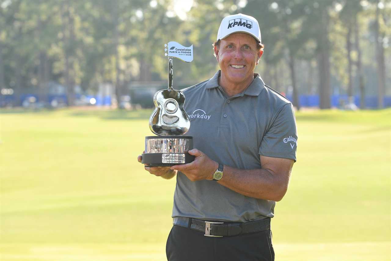 Phil Mickelson holds a trophy after winning a PGA Tour Champions event.