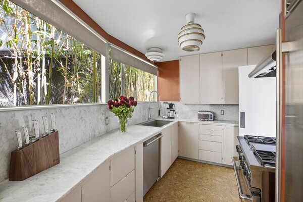 Despite its petite size, the bright and airy kitchen now features top-of-the-line appliances and marble countertops.