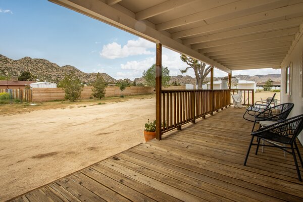 A covered wooden front porch offers captures striking views of the surrounding mountains.