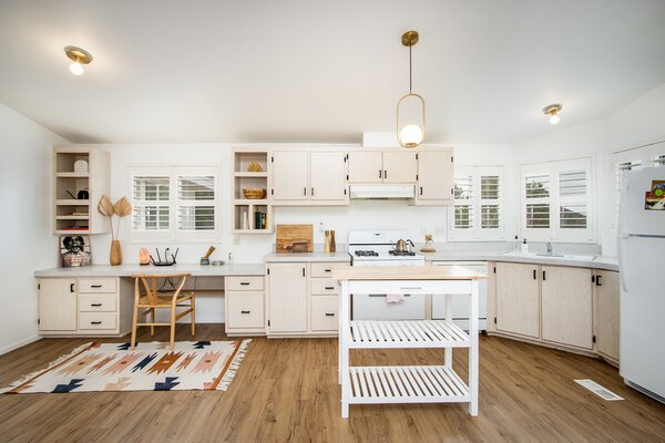 The airy kitchen features ample cabinetry and storage, as well as a built-in desk area.