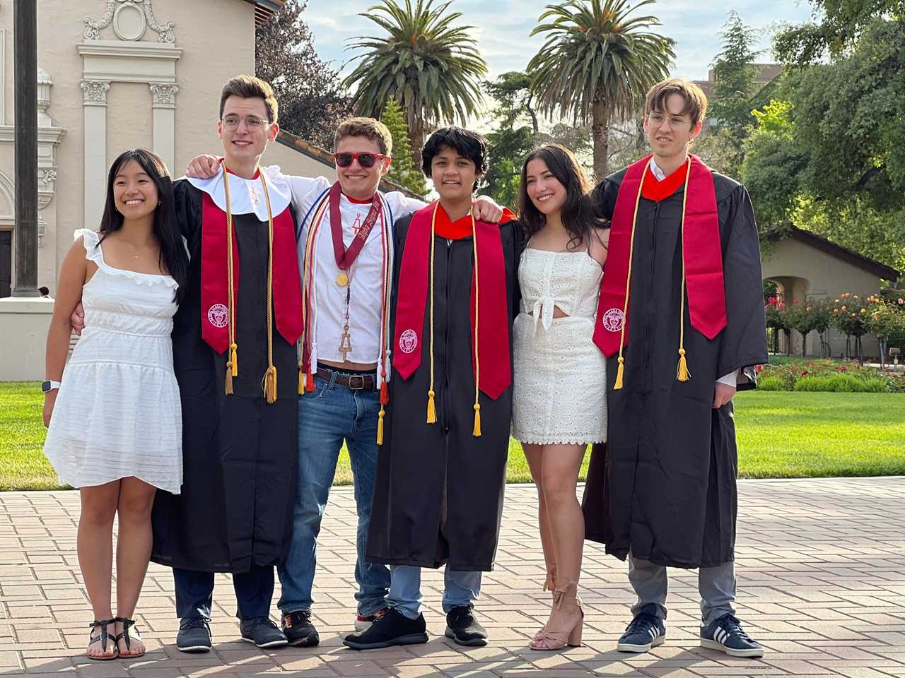 Kairan Quazi alongside his peers at their graduation this week  wearing black robes and red stoles