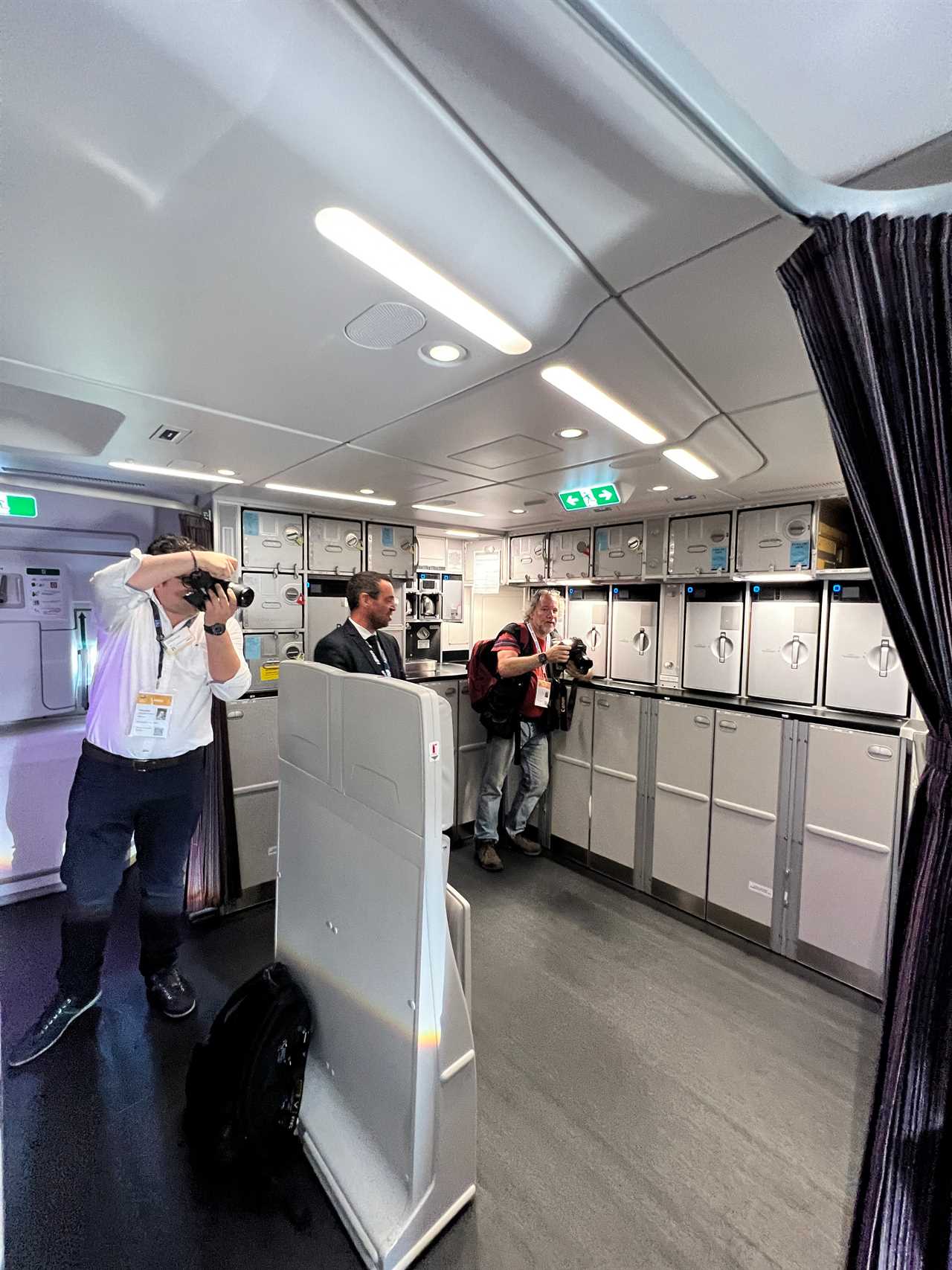 Two photographers and a spokesperson in the large rear galley of an Airbus A350