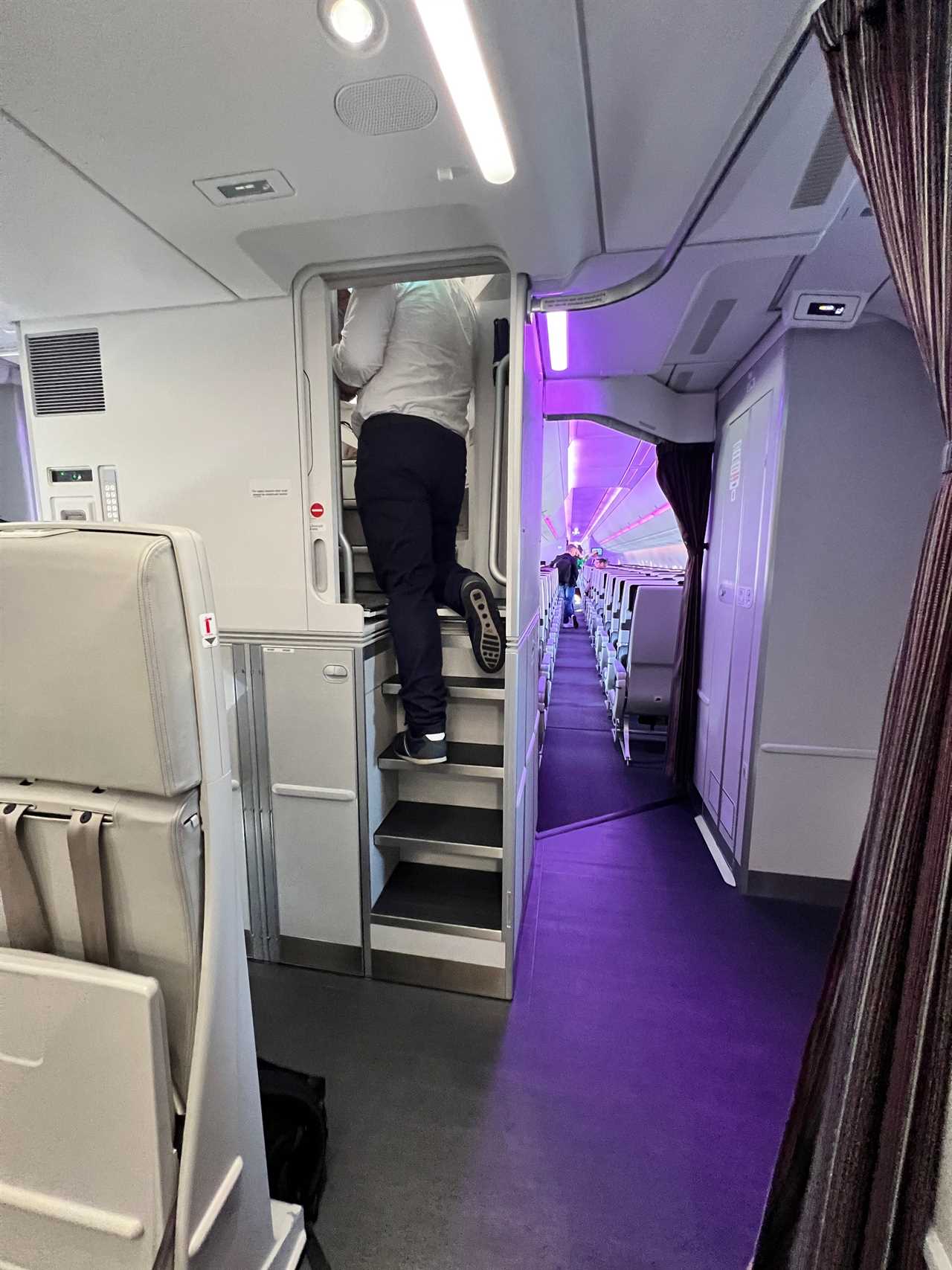 A man climbs up the narrow staircase to the A350's crew rest area.