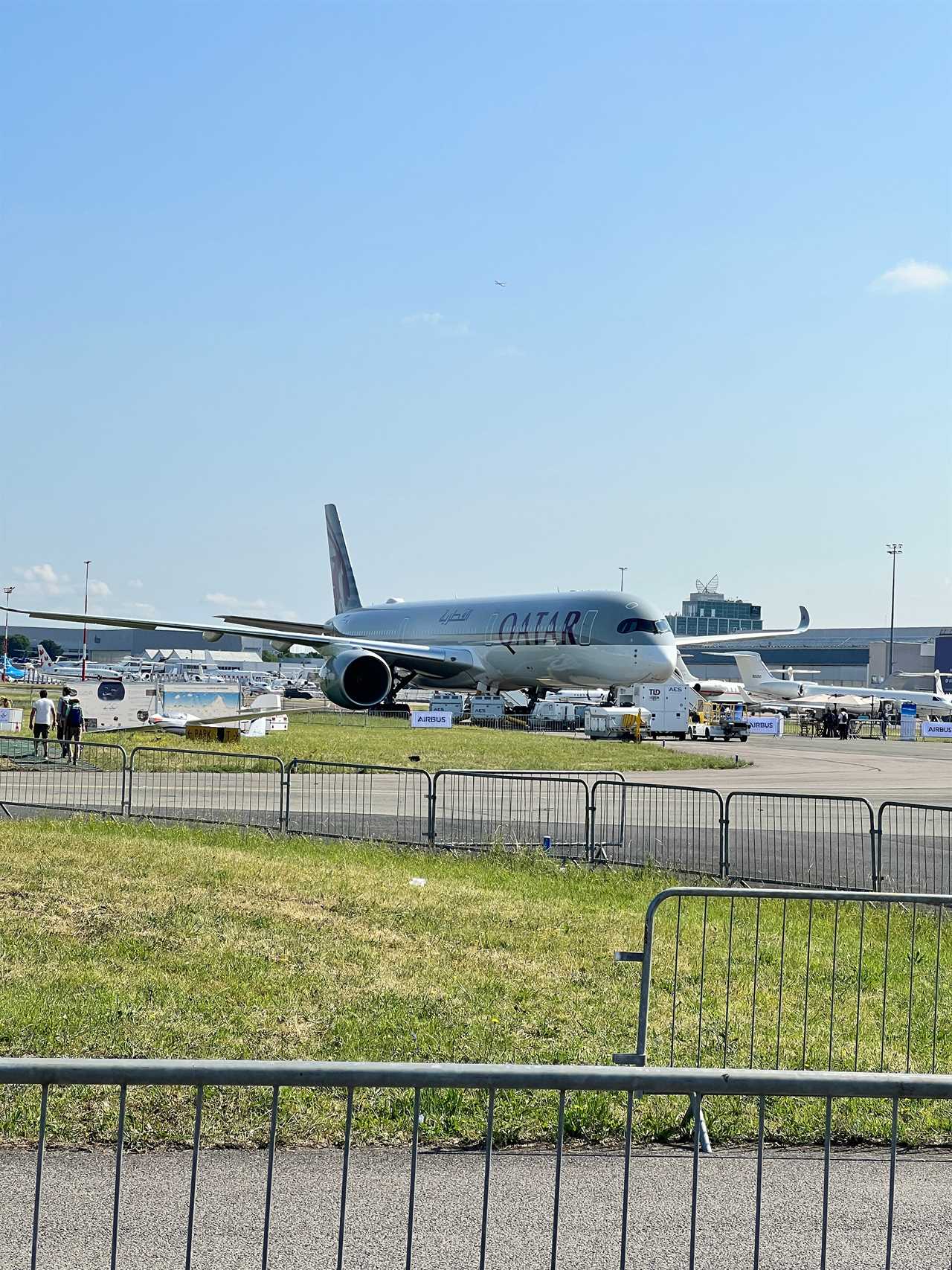 A long-distance shot of a Qatar Airways Airbus A350 in a silver livery at the Paris Air Show.