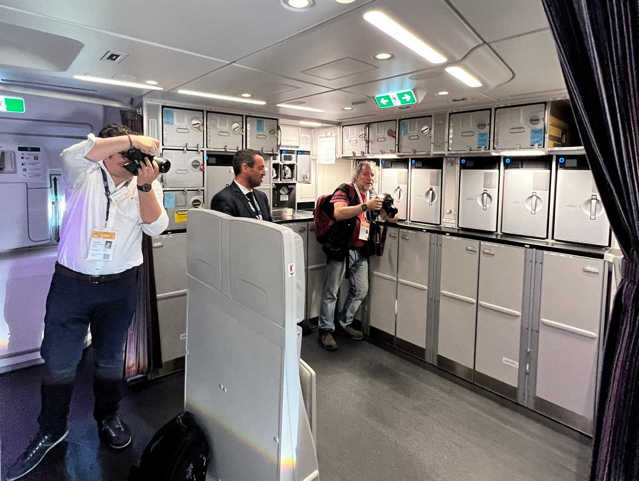 Two photographers and a spokesperson in the large rear galley of an Airbus A350