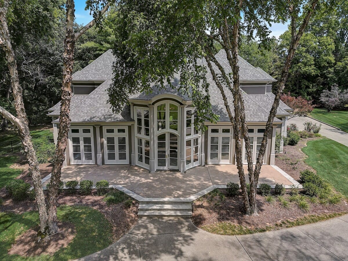 large home with large windows and greenery