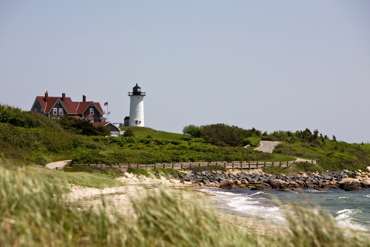 beach with waves and lighthouse in falmouth_Getty