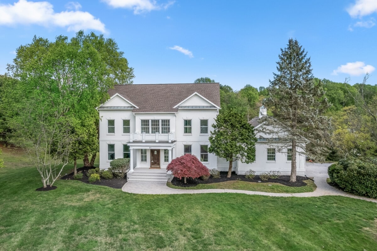 expansive white home with large trees