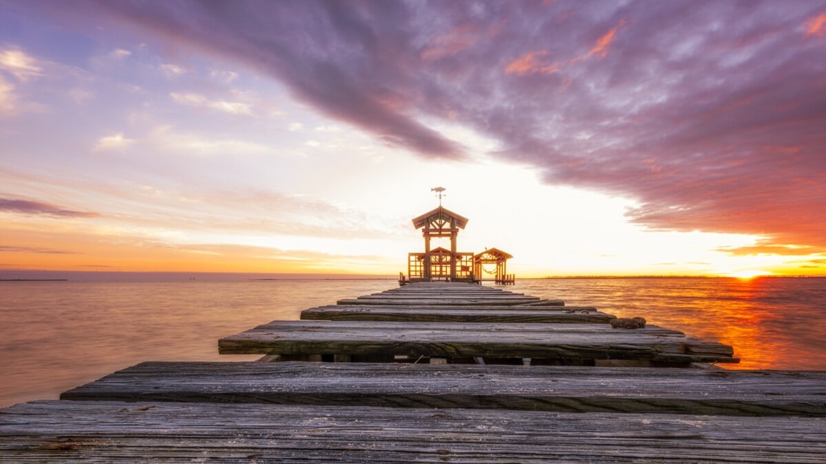 pier in ocean springs at sunset with purple sky