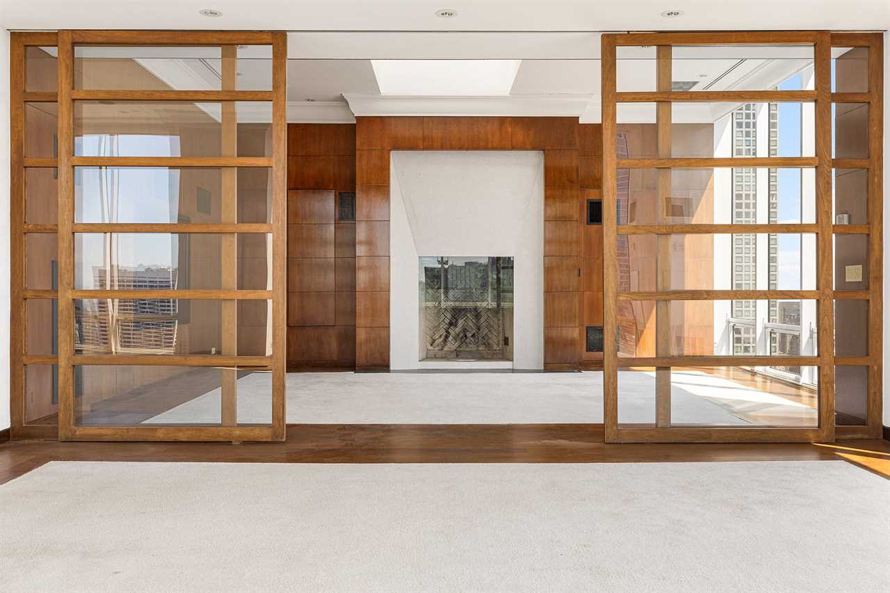 Sliding doors opening up to an empty penthouse library.