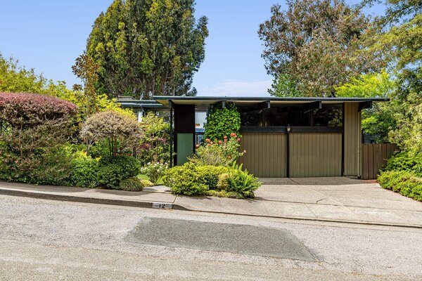 Attractively understated from the street, the home sits surrounded by soaring trees and mature native landscaping. The sizable cement driveway leads to the multi-car garage.