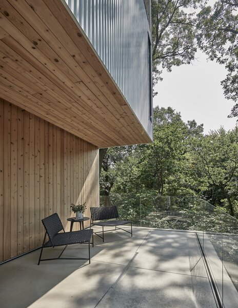 After rounding the house and climbing a set of concrete stairs, the home's entrance is revealed next to a Cedar-clad entry porch. The home has three separate decks, each oriented towards a different view of the site and natural surroundings.