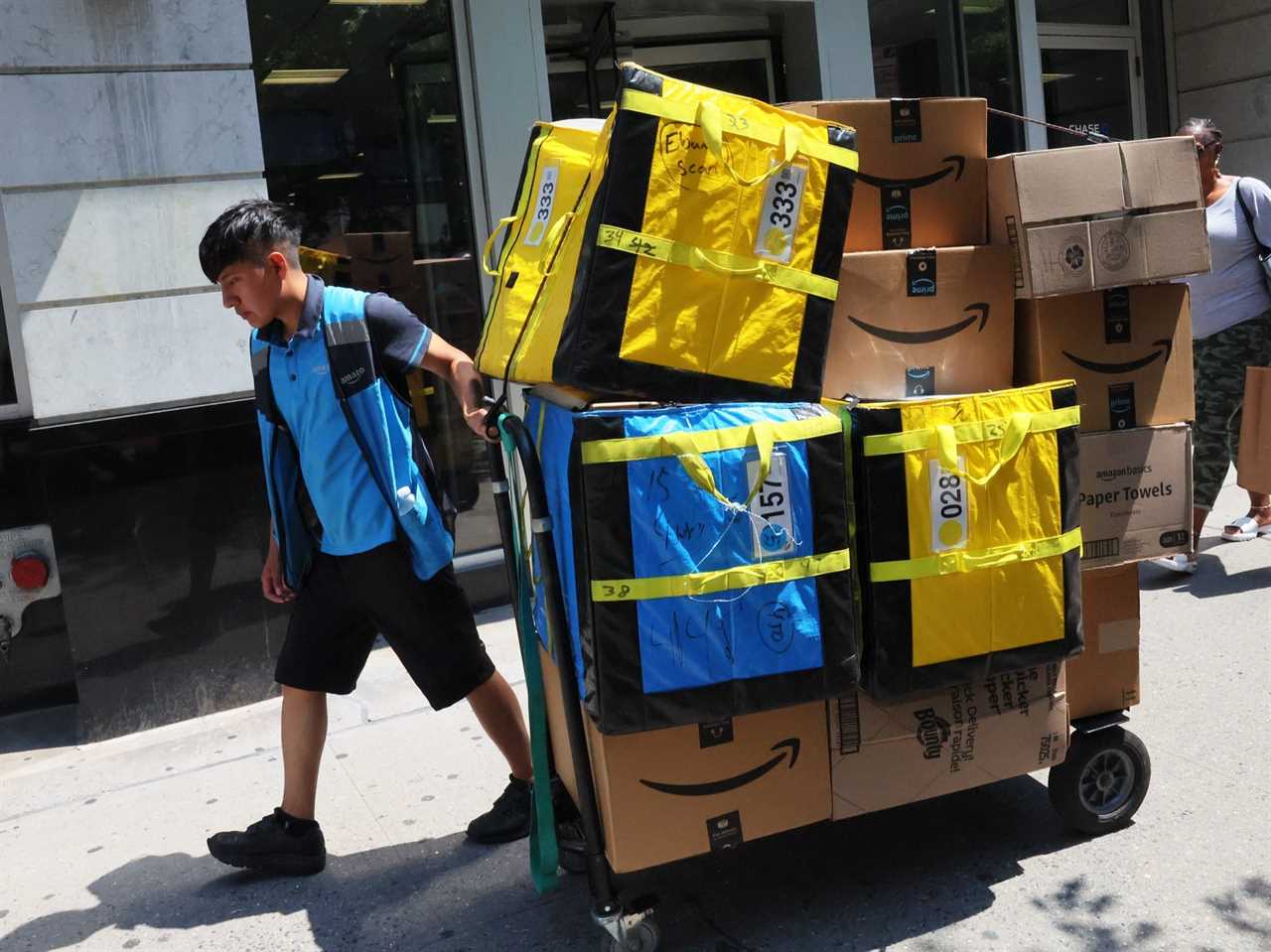 An Amazon workers pull a cart of packages for delivery