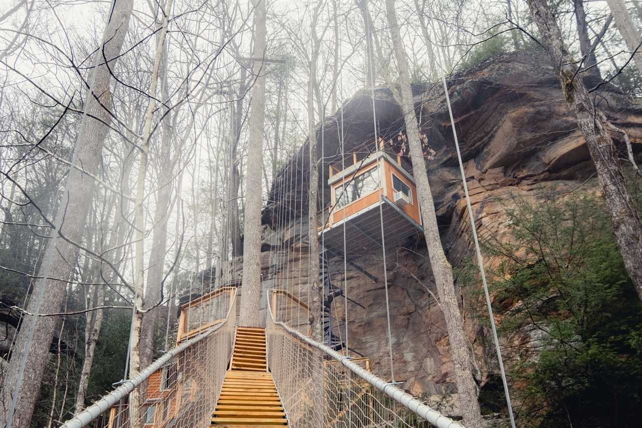 A staircase leading to another suspension bridge that takes guests up to treehouse lodging.