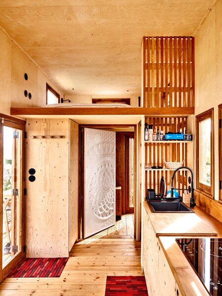 After months of waiting for approvals to build a house in Sintra, Portugal, artist Chris Saunders decided to pivot, commissioning a custom tiny home on wheels from architecture studio Madeiguincho. The 200-square-foot house, with its honey-colored wood cladding and contrasting blond wood interior, suits Chris perfectly. 