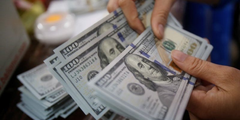 An employee of a bank counts US dollar notes at a branch in Hanoi, Vietnam May 16, 2016. REUTERS/Kham