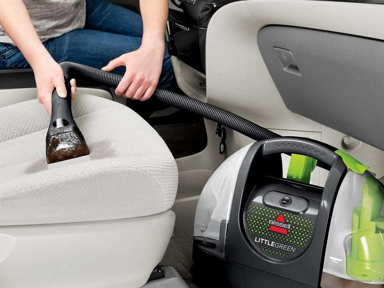 a person using the bissell little green to vacuum a car