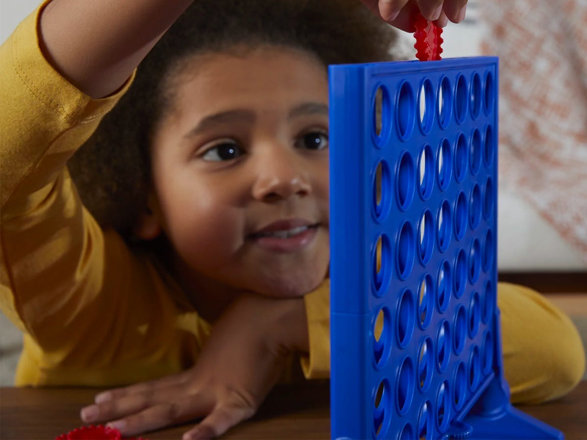 A kid playing with the Hasbro Connect 4 Game.