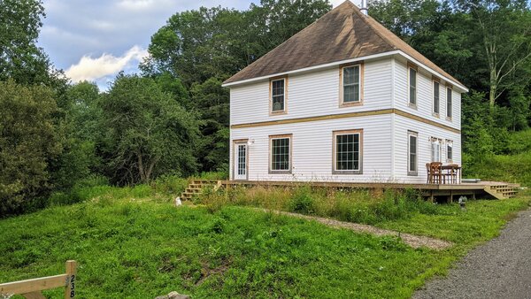 During: Fresh siding is installed and painted Benjamin Moore’s White Dove. A new wrap-around porch adds 900 square feet of living space.