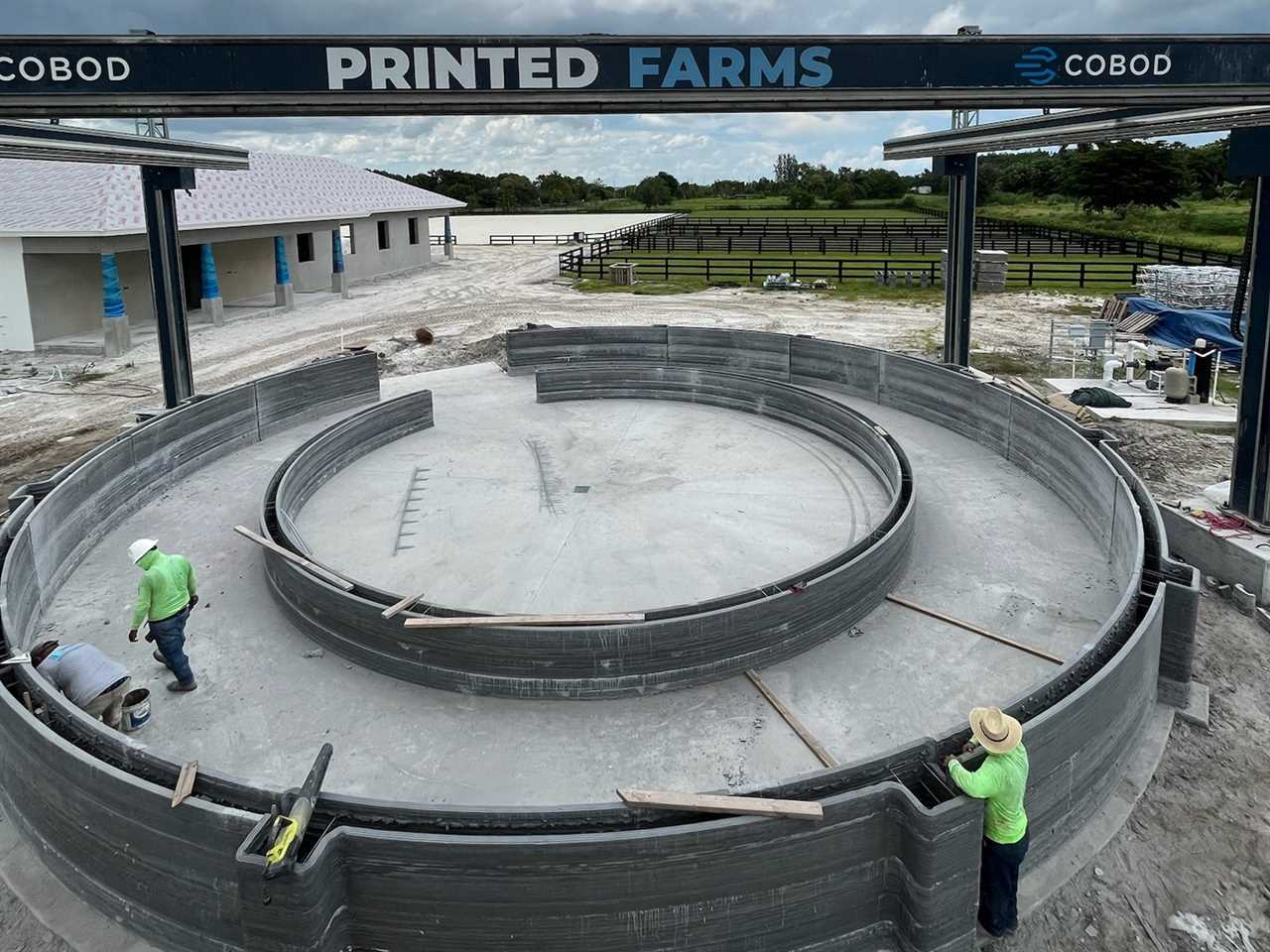 Two people working on the 3D printed horse walker