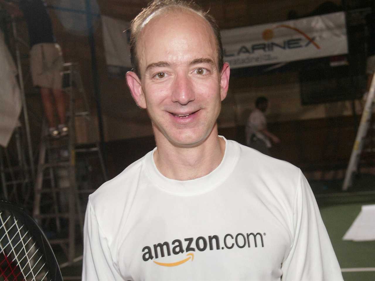 Jeff Bezos wears an Amazon.com t-shirt and holds a tennis racket after a round of charity tennis in 2003.