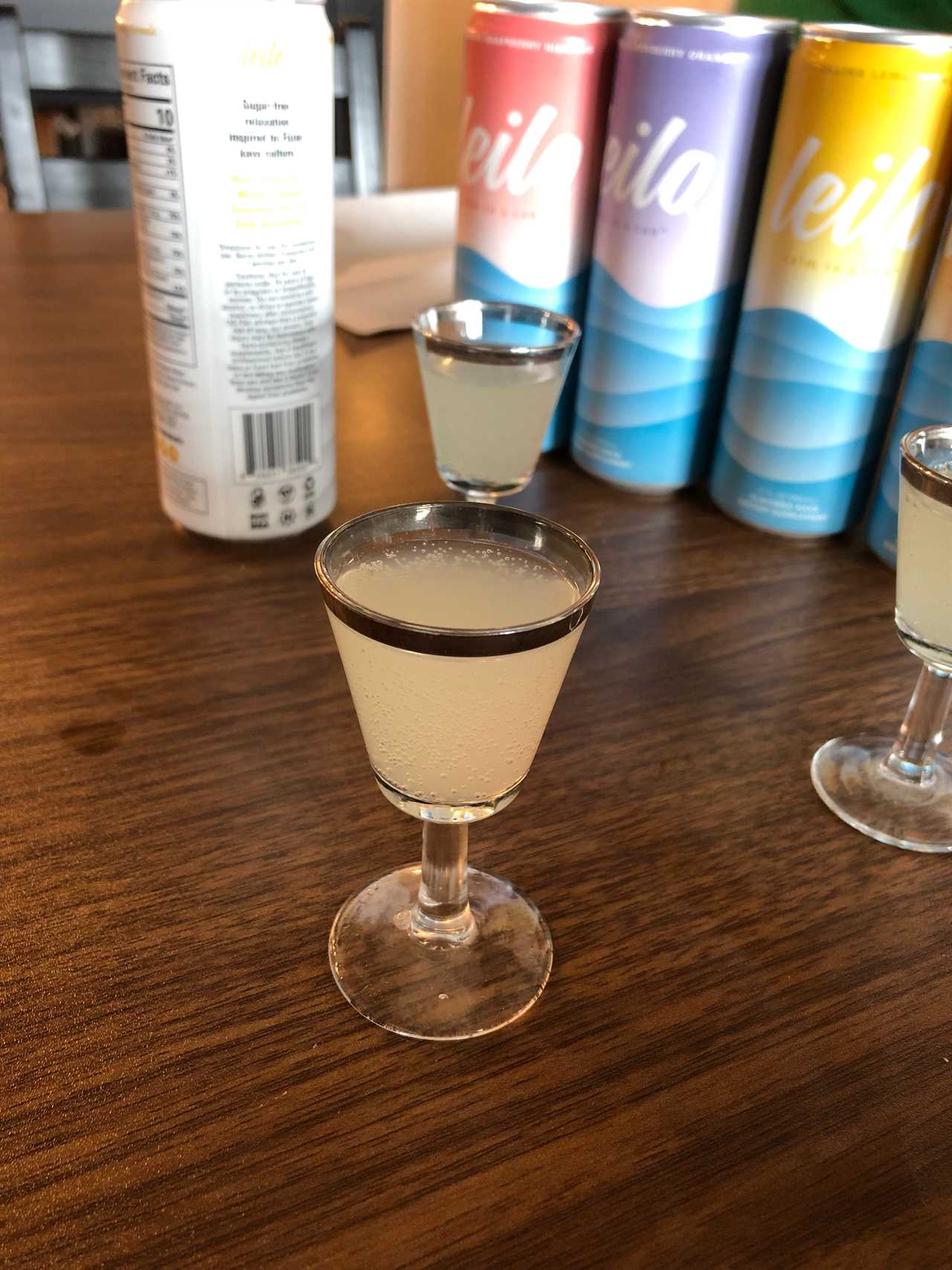 Some Leilo kava sits in a small glass goblet on a wood-grain table