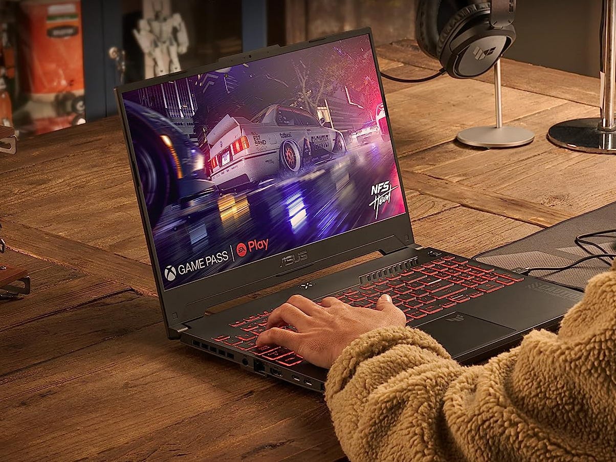 A person using Game Pass on an Asus TUF G15 gaming laptop on a desk.