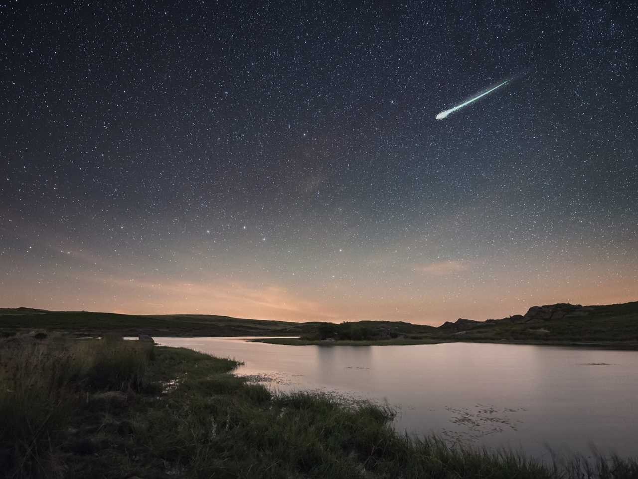 A big fireball is seen streaking over a lake in the early hours of the day.