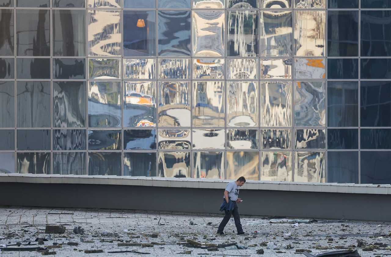 A man checks the debris next to a damaged office building in the Moscow City following a reported Ukrainian drone attack in Moscow, Russia, August 1, 2023.