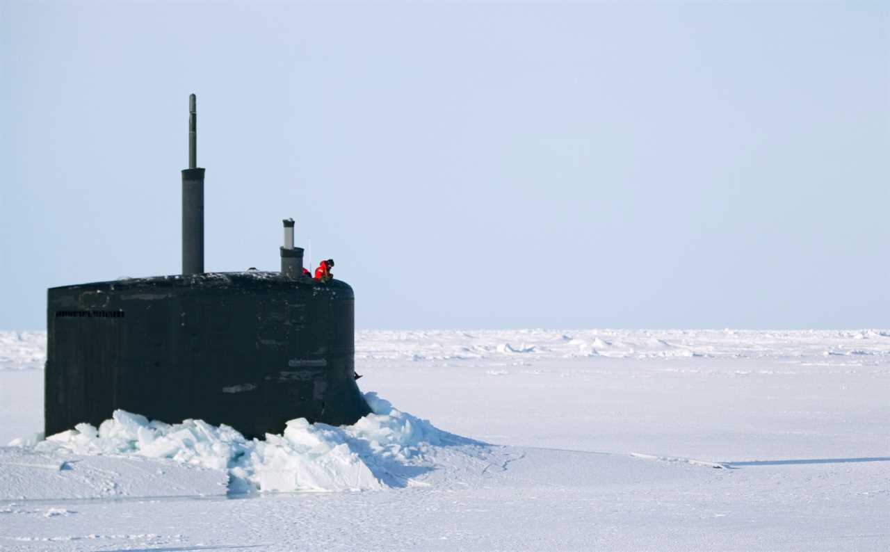 A US Navy sailor looks off the bridge of the Seawolf class submarine USS Connecticut after surfacing through Arctic sea ice during an exercise in Alaska in March 2011.