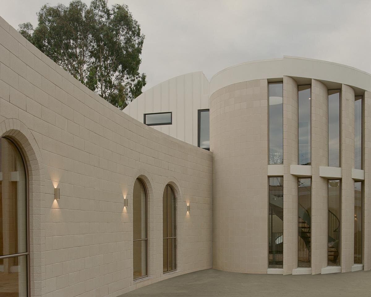 A series of curved walls and tall floor-to-ceiling windows face the interior courtyard of the home.